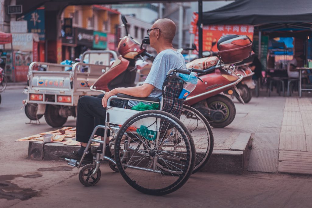 Wheelchair traveler in an Asian country street