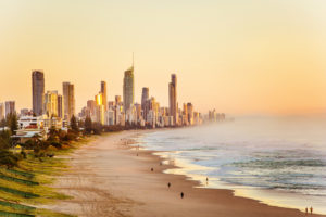 a picturesque view of the Gold Coast including skyline, beach and waves in the golden light of the setting sun